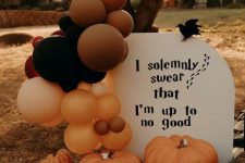 Harry Potter Halloween decor with oversized pumpkins and blackbirds, orange, blush and black balloons is amazing