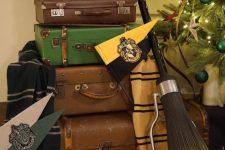 Harry Potter party decor with a suitcase stack, signs, blankets, a broom and some other stuff is perfect