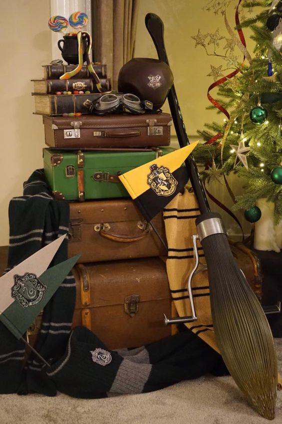 Harry Potter party decor with a suitcase stack, signs, blankets, a broom and some other stuff is perfect