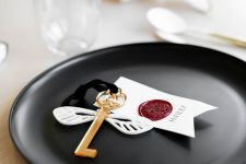 a Harry Potter Halloween place setting with a black charger, a key with wings and a tag is a cool idea