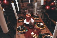 a Harry Potter party tablescape with a burgundy runner, pillar candles, gold and black plates, floating candles and bold balloons