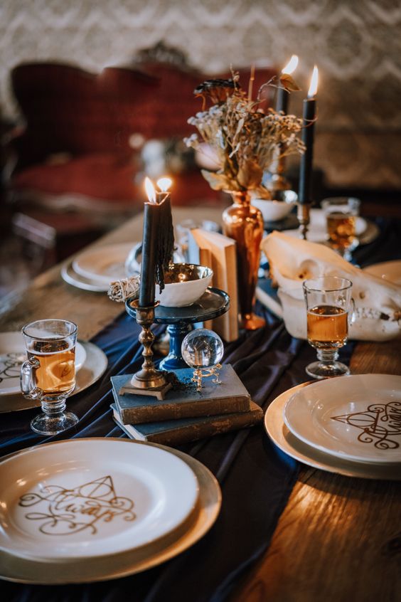 a Harry Potter themed tablescape with black candles, books, twigs in a vase and themed plates is a cool idea for a Halloween party
