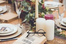 a Harry Potter themed tablescape with greenery, neutral and burgundy candles, books and eyeglasses