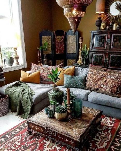 a Moroccan boho liivng room with a sectional sofa, printed pillows and rugs, a large Moroccan lantern, a wooden screen and a carved table