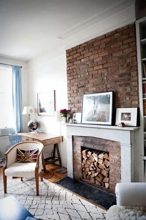 a beautiful neutral living room done in neutrals, with a red brick fireplace, a white mantel and cool and chic furniture