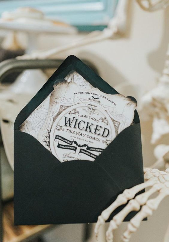 a black envelope paired with a creatively shaped invitation, all done in black and white, are a great idea for an adult Halloween party