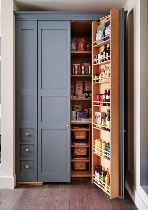 A blue built in pantry with stained shelves and baskets is a cool way to store your food and drinks in the kitchen