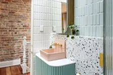 a bright bathroom with mint tiles, white terrazzo, a mint-colored vanity, a pink sink and a mirror cabinet