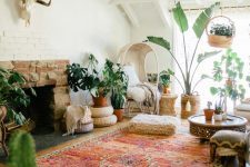 a bright boho living room with a fireplace, a bold rug, a chair, potted plants, a coffee tale and some cathcy decor