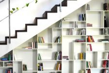 a built-in bookcase with geometrically placed shelves and books becomes a cool decor feature