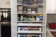 a built-in pantry organized right to store as much as possible, with shelves and drawers, containers, jars and various types of food