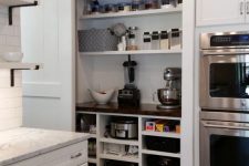 a built-in pantry with a barn door, open storage units, shelves, food, appliances and cookware is a cool idea for a rustic space