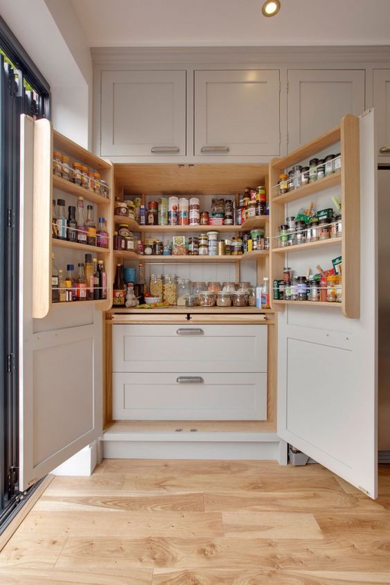 a built-in pantry with grey panels and doors, stained shelves, grey drawers is a cool idea for a farmhouse kitchen