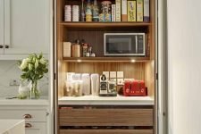 a built-in pantry with open shelves and LED lights, drawers, some food, appliances and spices and oils