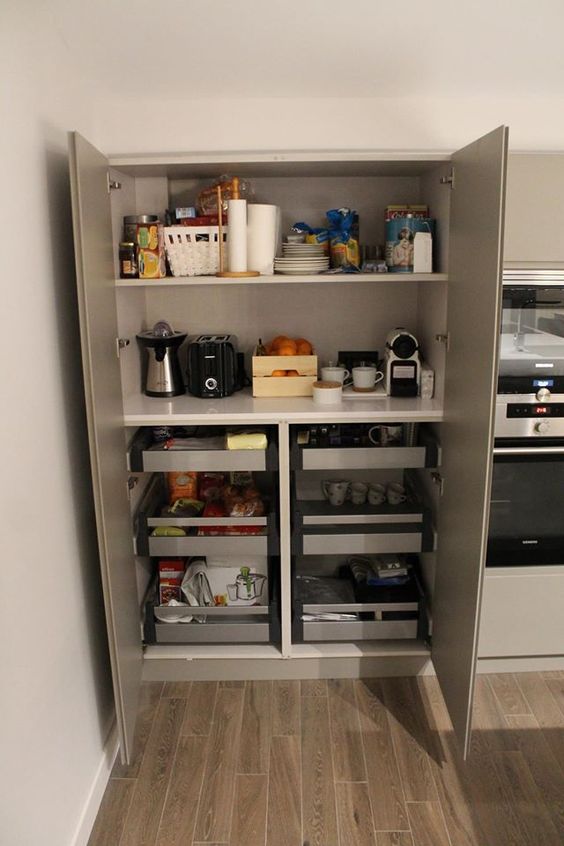a built-in pantry with open shelves and drawers, with appliances, tableware, various cups, mugs and other stuff