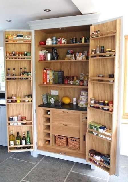 A built in pantry with shelves, drawers, baskets, shelves on both doors and various oils, fodo, drinks and spices