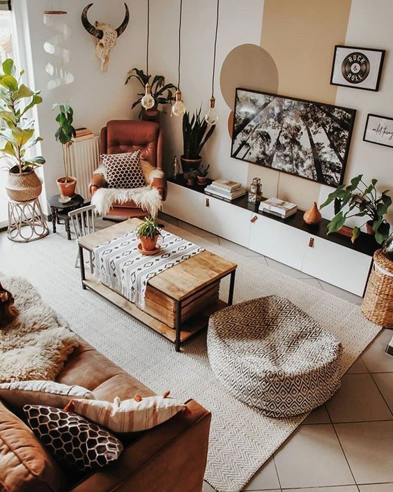 a catchy boho living room with an amber sofa, pillows, a brown chair, a coffee table, a pouf, boho decor and plants