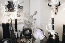 a chic witch’s nook with a cauldron with smoke, candles, crystals, a sphere and some signs is a gorgeous idea for Halloween