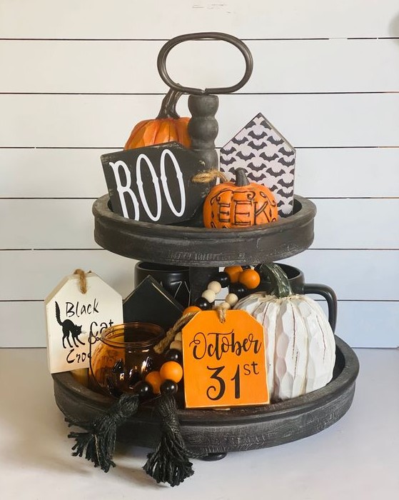 a classic Halloween stand with bright beads, orange pumpkins, candle lanterns and wooden signs with Hallowene prints