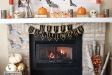 a classic rustic Halloween fireplace with grey bats, orange and grey candles, pumpkins and fall leaves