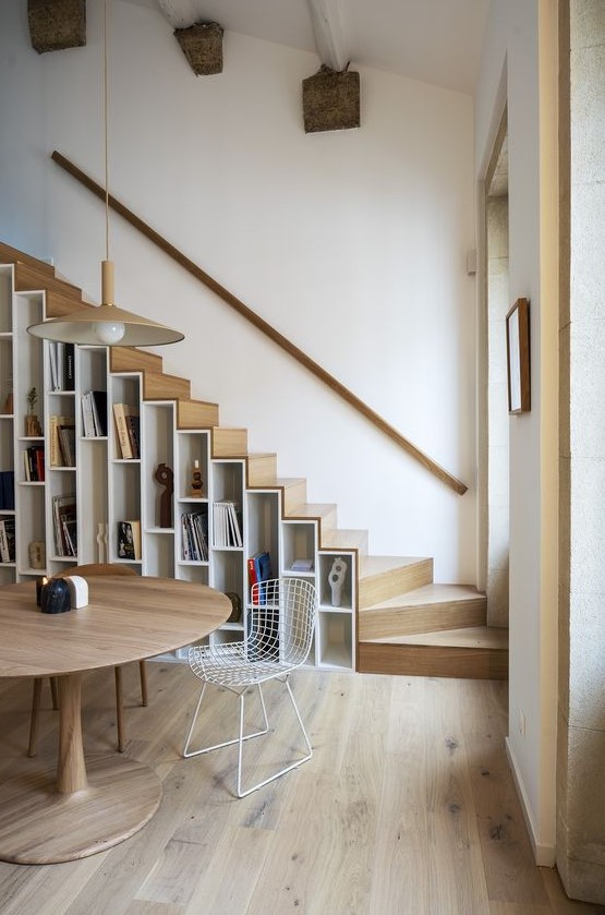 A contemporary light stained staircase with shelves built in, both for books and other items for displaying