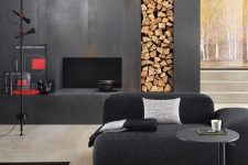 a contemporary monochromatic interior finished with a faux fireplace clad with metal sheets and with a firewood storage niche