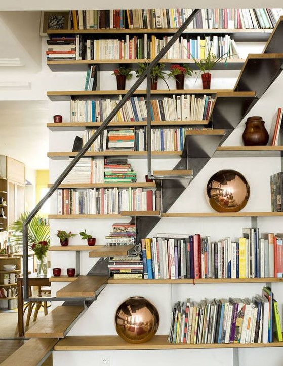 a contemporary space with a bookcase covering the wall next to the stairs and bookshelves that cover the side of the staircase