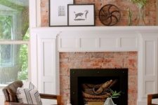 a cozy mid-century modern living room with a red brick fireplace, a chic white mantel with decor that matches a stool