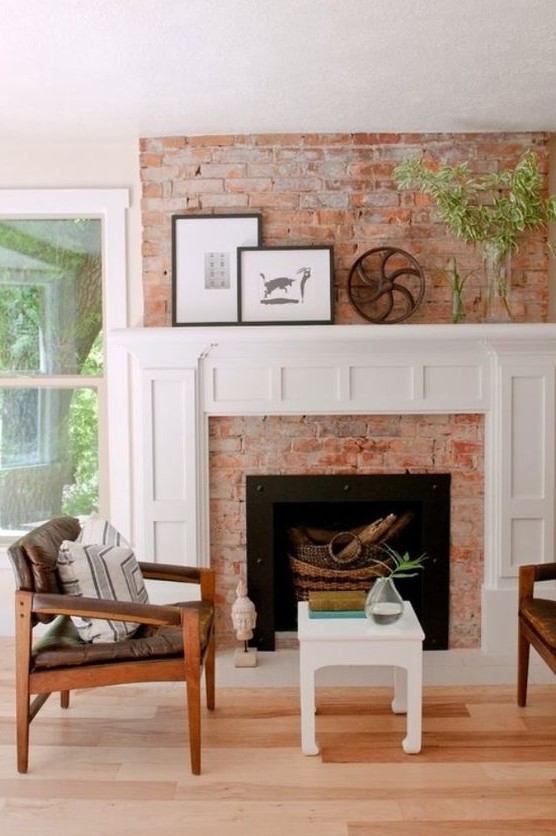 A cozy mid century modern living room with a red brick fireplace, a chic white mantel with decor that matches a stool