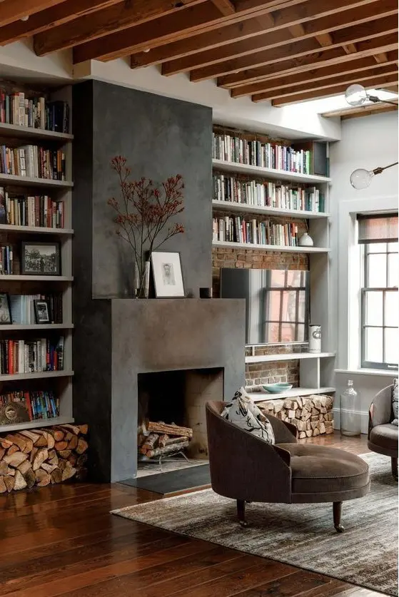 A cozy warm colored living room with wooden beams, built in shelves, a fireplace clad with metal and round chairs