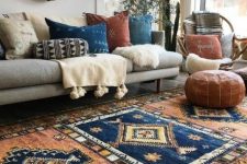 a gorgeous boho living room with boho rugs, pillows, faux fur and leather, decorative baskets and potted greenery