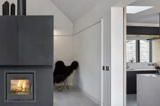 a hearth clad with black metal with firewood storage is a gorgeous way to cozy up your Scandinavian space