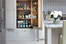 a large built-in pantry with lots of shelves, a shelving unit on the door, drawers is ideal to store all the food and drinks you need