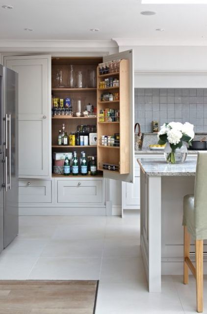 a large built-in pantry with lots of shelves, a shelving unit on the door, drawers is ideal to store all the food and drinks you need