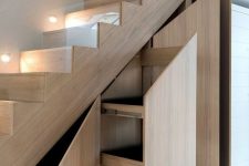 a light-stained staircase with storage drawers and compartments is a cool idea for any modern home