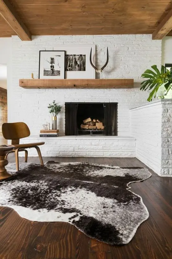 A mid century modern living room all done with white bricks and stained wood looks very cozy