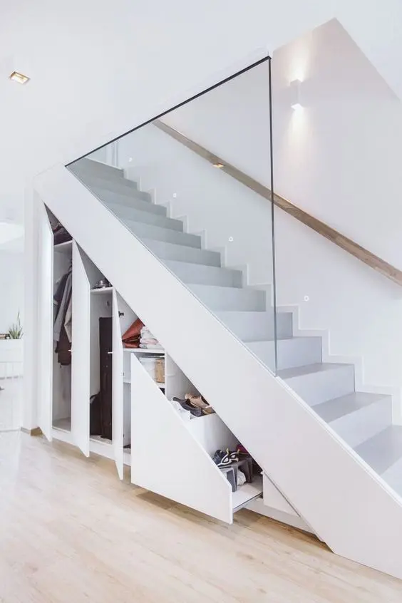 a minimalist white staircase with built-in storage units and drawers, which are a smart solution to save some space