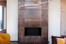 a modern fireplace clad with darkened copper looks really wow and impressive and will make a statement in the space