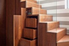 a modern stained staircase with drawers and hidden storage compartments is a cool solution for a modern home