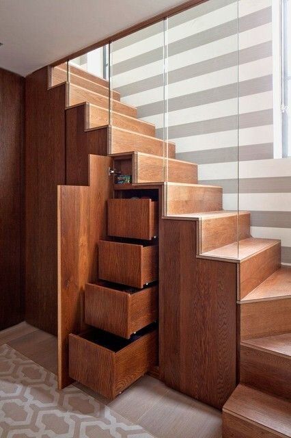 a modern stained staircase with drawers and hidden storage compartments is a cool solution for a modern home