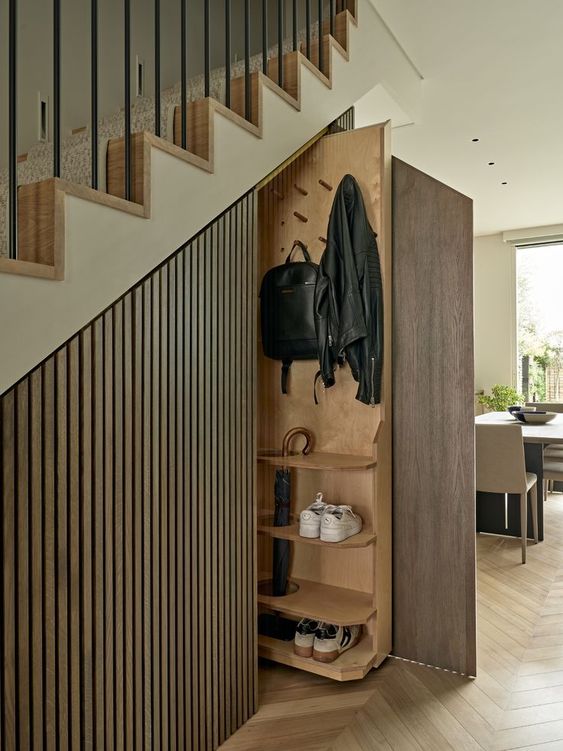 A modern staircase with stained wood slats and built in retracting storage shelves and rails is a cool and smart idea