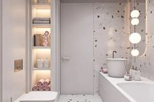 a neutral bathroom with neutral terrazzo walls and a floor, built-in lights and pink and blush touches