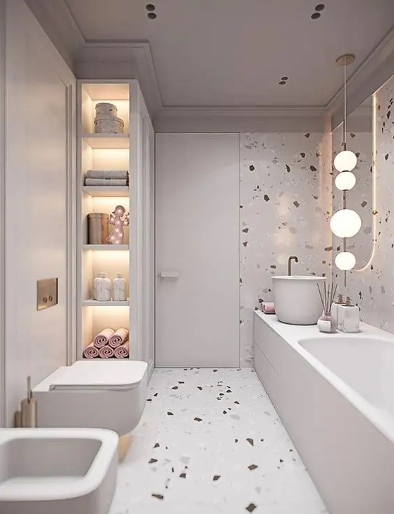 A neutral bathroom with neutral terrazzo walls and a floor, built in lights and pink and blush touches