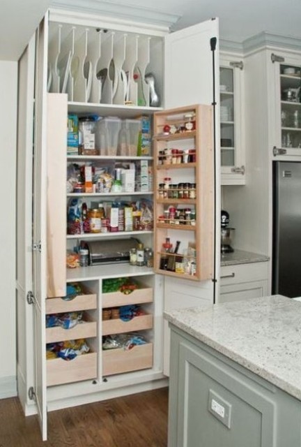 a neutral kitchen with a built-in pantry with lots of various shelves and drawers to store everything you may need