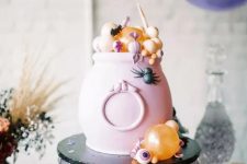 a pink cauldron with candies and sweets in pastel colors is a great way to serve some food in a truly Halloween way