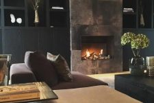 a refined moody living room with a built-in fireplace clad with a dark metal surround that adds glam and chic to the space