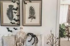 a rustic Halloween entryway with stacked white pumpkins, branches with lights, bats and a skeleton