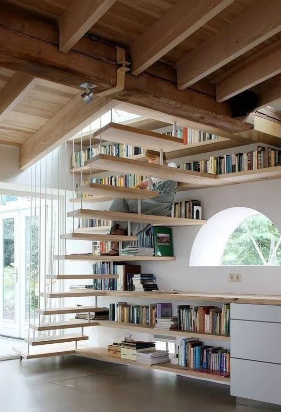 a semi circle window, some drawers and open shelving that also forms steps of the staircase