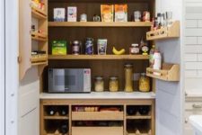 a small built-in pantry with stained shelving, drawers and some shelves on the doors is a cool idea for a modern farmhouse kitchen