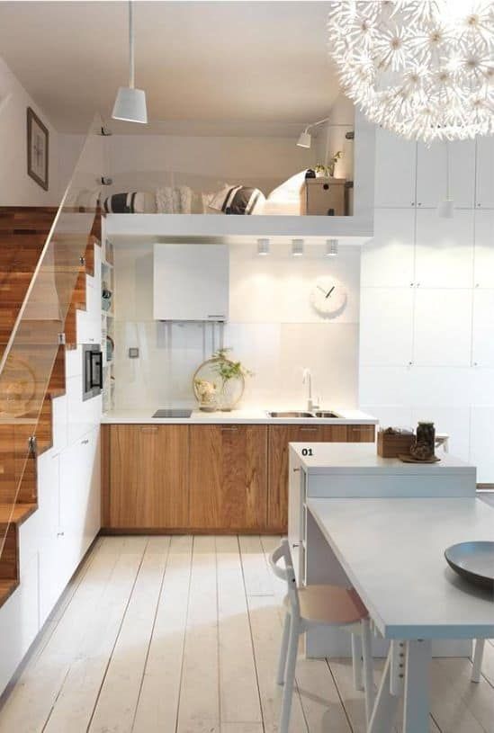 A small modern loft with a staircase as a built in storage unit, stained cabinets, a hood and a kitchen island with a table